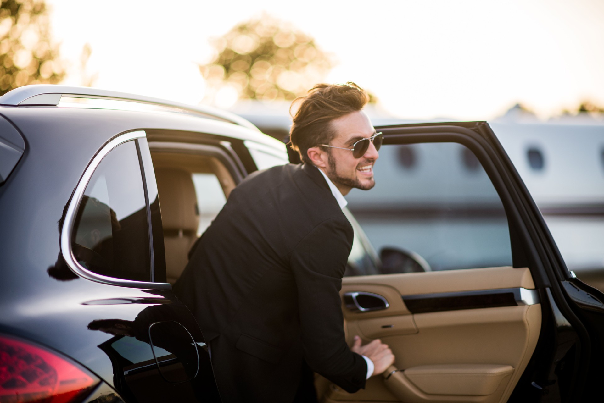 Man with sunglasses exits the black car